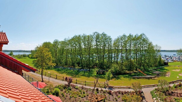 Vista de una propiedad frente al lago con muelle de madera, zona de picnic y embarcadero.
