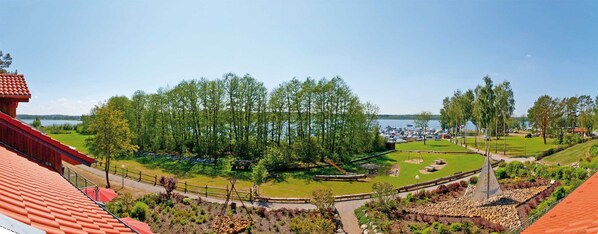 Vue d’une propriété au bord du lac, avec une terrasse en bois, un espace pique-nique et un quai pour bateaux.