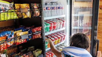 Ein gekühlter Warenpräsentationskühlschrank im Geschäft mit verschiedenen Snacks und Getränken.