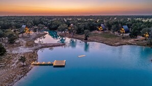A lakeside property with multiple cabins, a dock, and a clear view of the surrounding forest. - A quiet A-frame escape in the Texas countryside, made for slowing down. (Ledbetter)