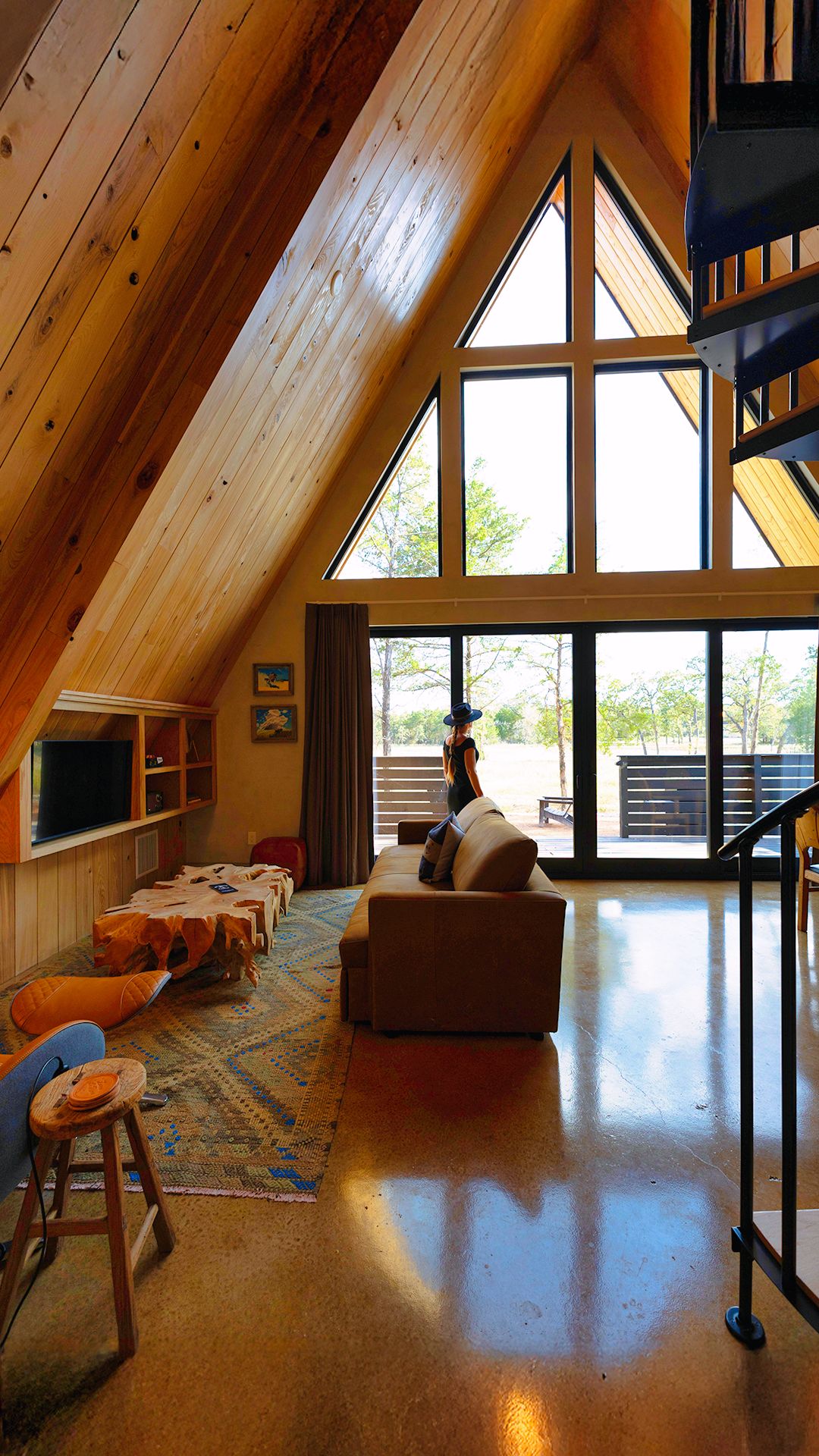 Un loft espacioso con techos altos, ventanas amplias, una zona de estar acogedora y una escalera.