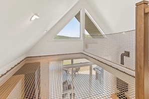 A room with a sloped ceiling, a skylight, and a metal mesh floor. - Spa, Nature & Mountain | Chalet des montagnes (Saint-Côme)