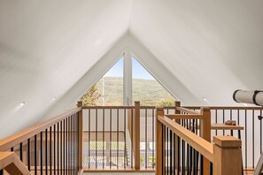 A high-ceilinged room with a large window, wooden railing, and a telescope. - Spa, Nature & Mountain | Chalet des montagnes (Saint-Côme)