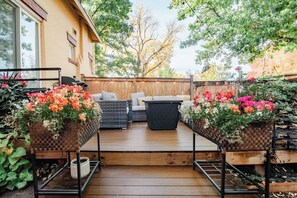 Une terrasse en bois avec des meubles d’extérieur et des jardinières.