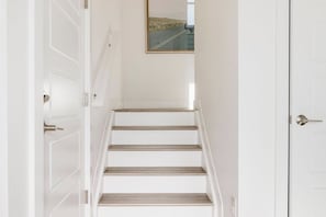 Eine Treppe mit weißen Wänden und einem Bild darüber.