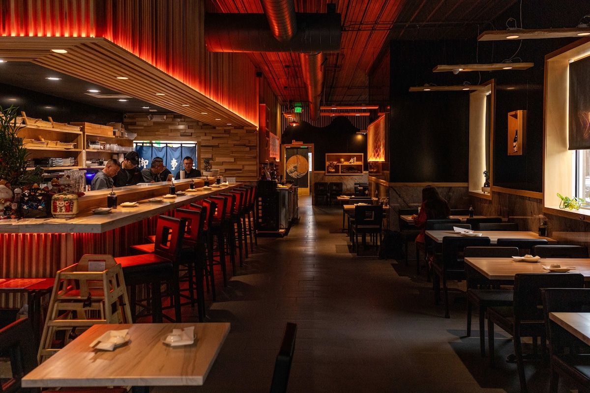 Un interno ristorante con area bar, posti a sedere e bancone.