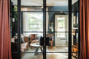 A living room with a sofa, chairs, a coffee table, and a view through a glass door to the outside. - Boutique 1BD Townhome w/Great Patio in Wash Park (Denver)