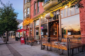 A brick building with a storefront, outdoor seating, and a bicycle parked in front. - Boutique 1BD Townhome w/Great Patio in Wash Park (Denver)