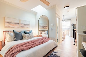 A bedroom with a large bed, a skylight, and artwork on the wall. - Boutique 1BD Townhome w/Great Patio in Wash Park (Denver)