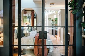 A bedroom with a bed, a nightstand, and a window. - Boutique 1BD Townhome w/Great Patio in Wash Park (Denver)