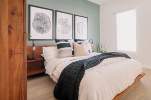 A bedroom with a bed, bedside tables, framed artwork on the wall, and a window. - Home Away from Home w/Sauna 4BD|2BA | Berkley (Denver)
