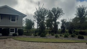 A residential property with a house, a gravel driveway, and a fenced yard.