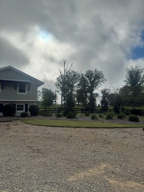A residential property with a house, a gravel driveway, and a fenced yard.