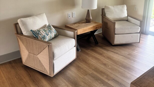 A room with two armchairs, a wooden side table, and a floor lamp.