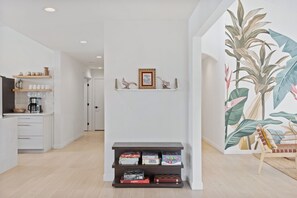 Ein modernes Interieur mit Küchenbereich, Flur und Wohnraum mit einer großen Wandmalerei.