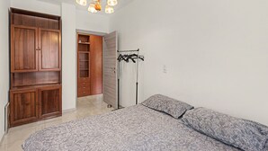 Ein Schlafzimmer mit Bett, Kleiderschrank und Garderobe.