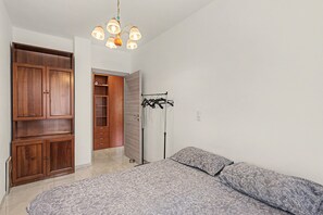 A bedroom with a bed, wardrobe, and a coat rack. - Apartment 'Martina House' with Mountain View, Balcony and Wi-Fi (Taggia)