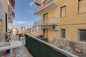 A residential building with balconies, a terrace with a table and chairs, and a view of the surrounding neighborhood. - Apartment 'Martina House' with Mountain View, Balcony and Wi-Fi (Taggia)