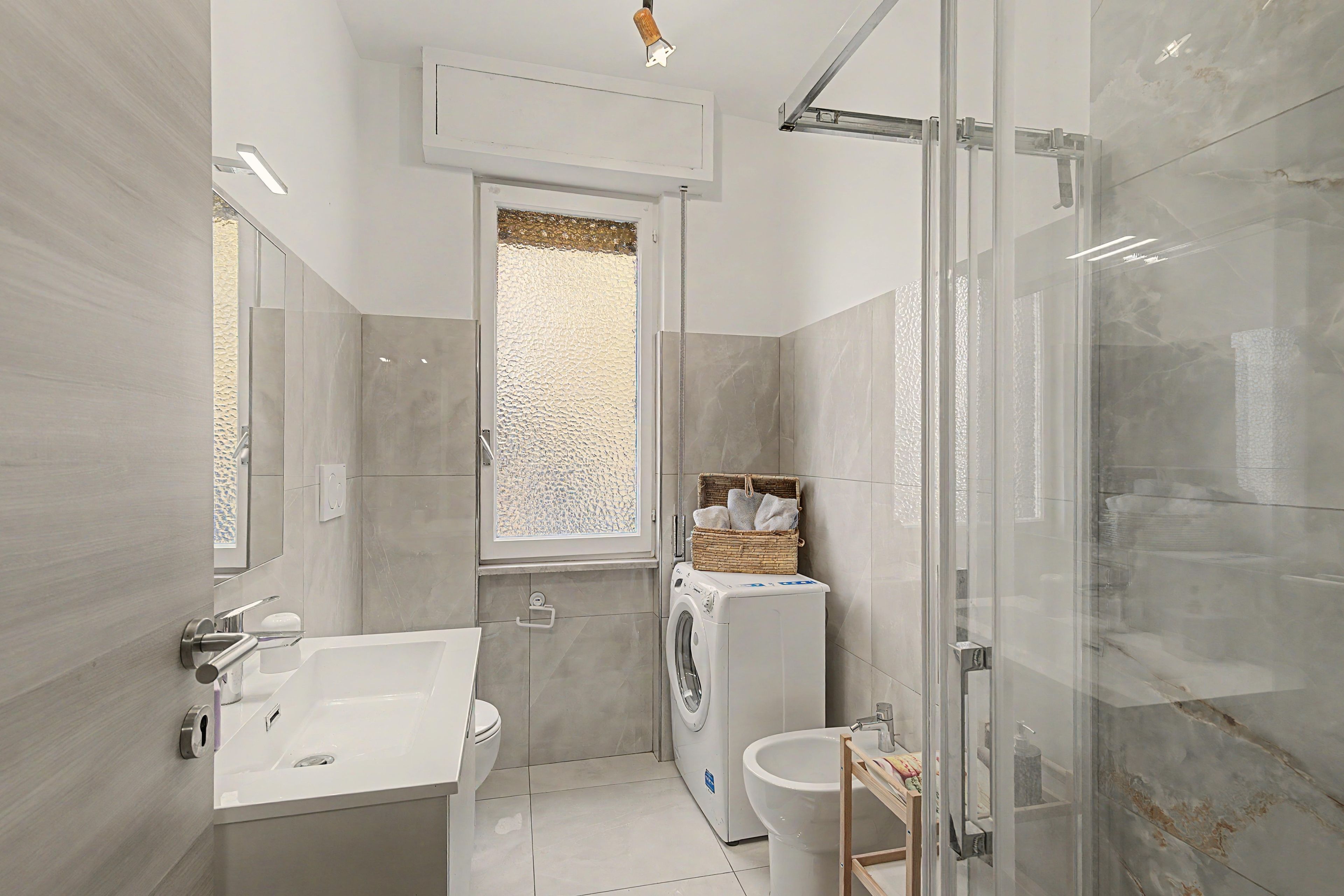 Un baño moderno con bañera, inodoro y lavadora.