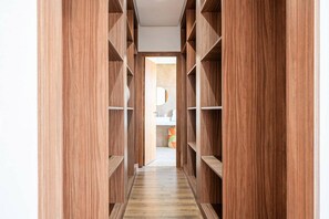 A narrow hallway with wooden shelving units on both sides, leading to a bathroom area. - Villa Palm Atlas | Piscine Chauffé | proche centre (Marrakesh)