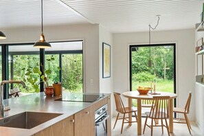 Eine moderne Küche mit einer großen Kochinsel, Holzstühlen und einem Esstisch.