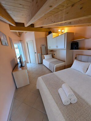 Habitación de hotel con dos camas, un escritorio y un armario.