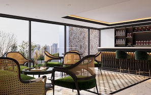 A modern bar area with a city view, featuring wicker chairs, a bar counter, and a large window. - Mayan Hanoi Residence (Hai Ba Trung)