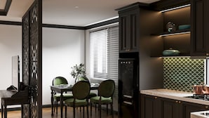 Una cocina moderna con armarios oscuros, una mesa de comedor de madera y una estufa empotrada.
