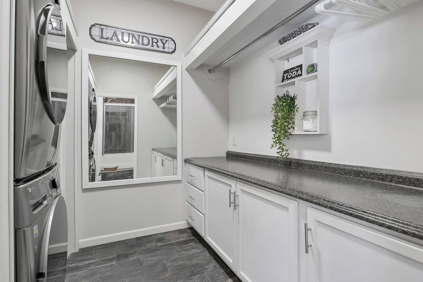 A kitchen with a stainless steel refrigerator, a sign labeled 'LAUNDRY,' and a plant on the counter.