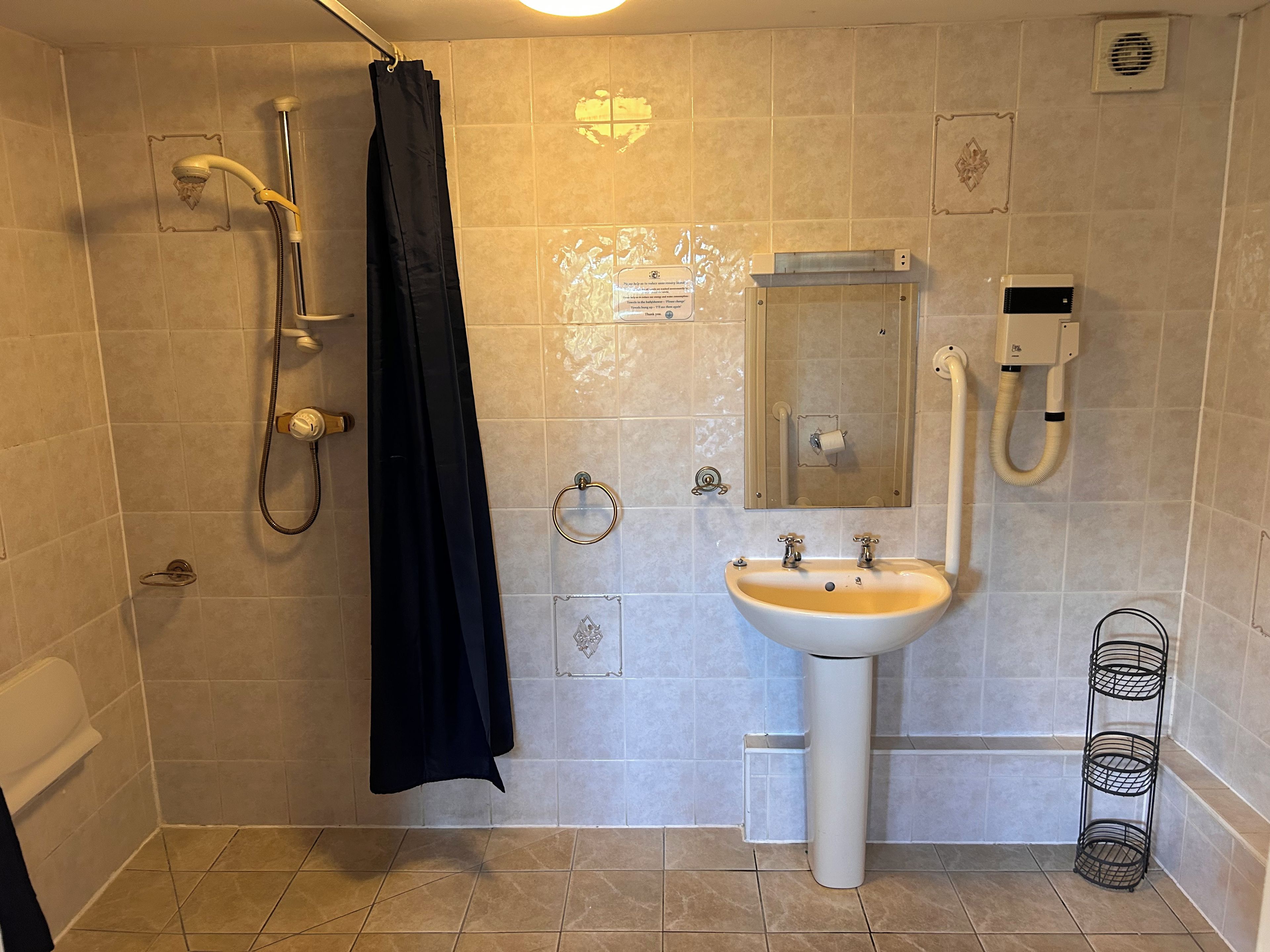 Un baño con ducha, lavabo y espejo.