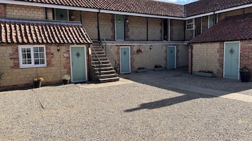 A building with a courtyard, a staircase, and multiple doors.