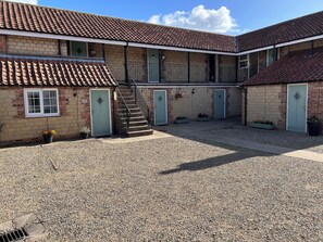 A building with a courtyard, a staircase, and multiple doors. - The Ganton Greyhound (Scarborough)