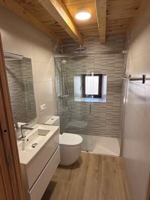 Ein modernes Badezimmer mit einer einteiligen Duschkabine, einer Toilette und einem Waschbecken.