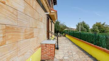 A building with a stone facade, a brick entrance, and a yellow and green wall.