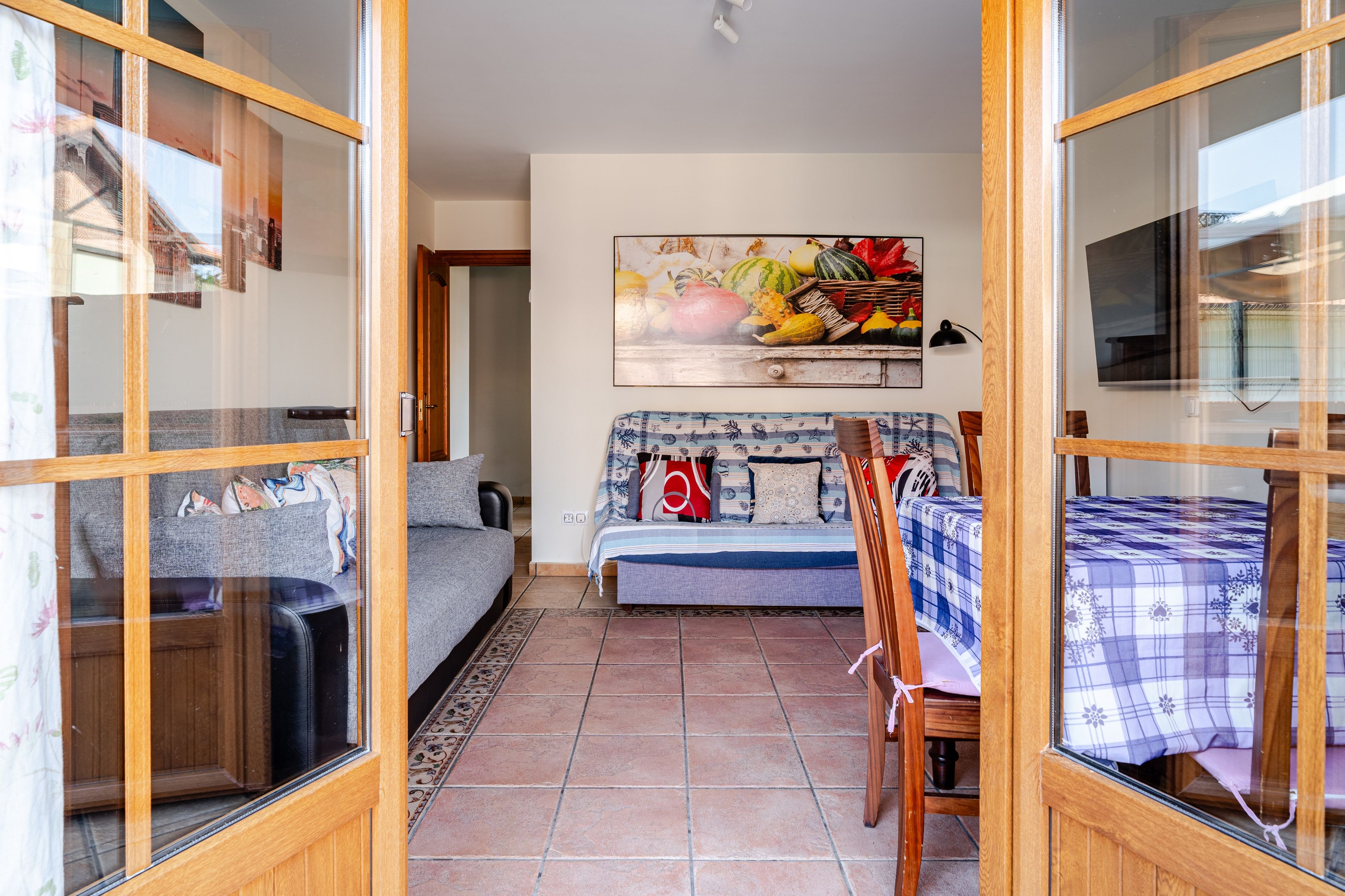 Una habitación con un sofá, una mesa de comedor y un cuadro en la pared.