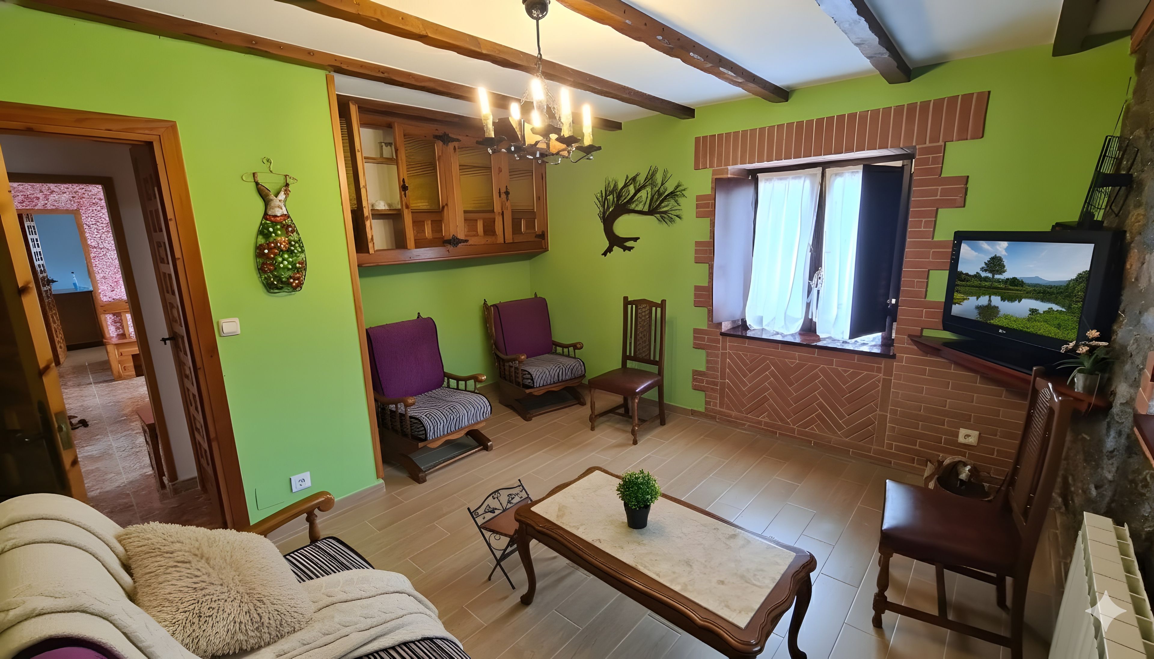 A living room with a television, wooden furniture, and a green wall.