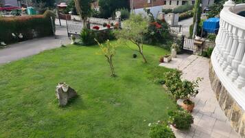 Ein gepflegter Garten mit vielfältigen Pflanzen und einem Steingebilde.