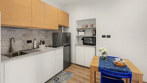 A compact kitchen with white cabinets, a built-in oven, and a microwave. - Apartment 'Mimi' with Balcony, Wi-Fi and Air Conditioning (Taggia)