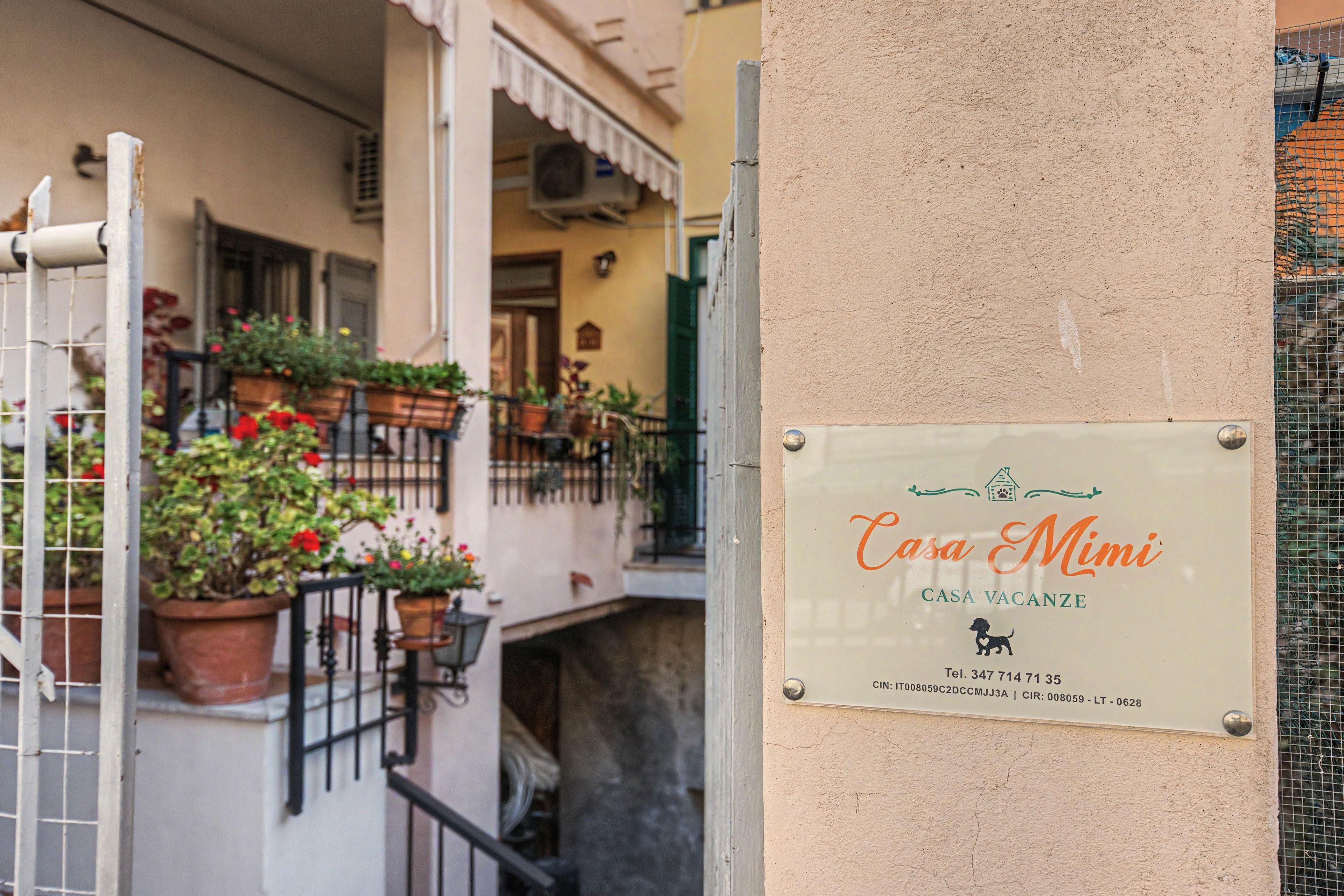 Une enseigne indiquant « Casa Mimi », un nom qui désigne une maison de vacances, avec un numéro de téléphone et une adresse.