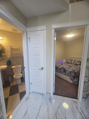 A bathroom with a toilet, sink, and mirror.