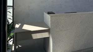A reception desk with a logo for 'NOMAR CARNEIROS ECOLIVING' against a textured wall. - Feet in the sand in Carneiros - Nomar (Tamandaré)