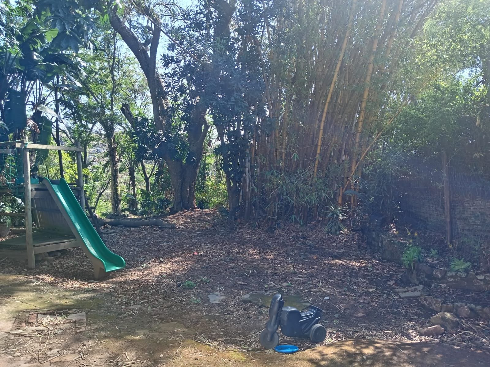 A playground with a slide and a dirt ground.