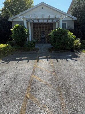 A building with a garage entrance, a porch with columns, and a statue in front. - A Serene Stay - Room #15 at The Inn At Herr Ridge (Gettysburg)