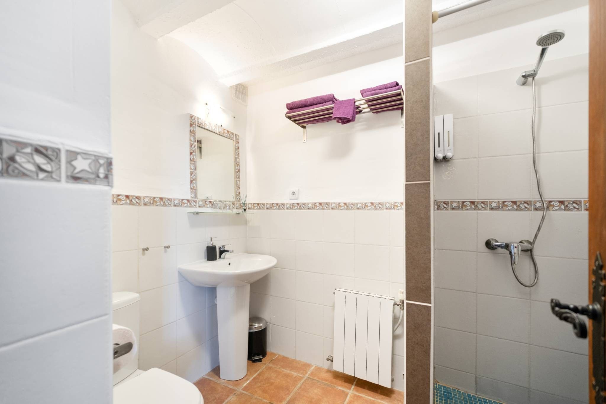 A bathroom with a sink, toilet, and shower.
