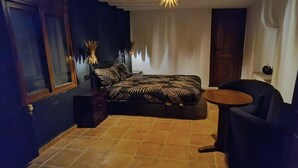 A compact bedroom with a bed, a small round table, and a chair. - Room 'Calabaza' with Mountain View, Wi-Fi and Air Conditioning (Lorca)