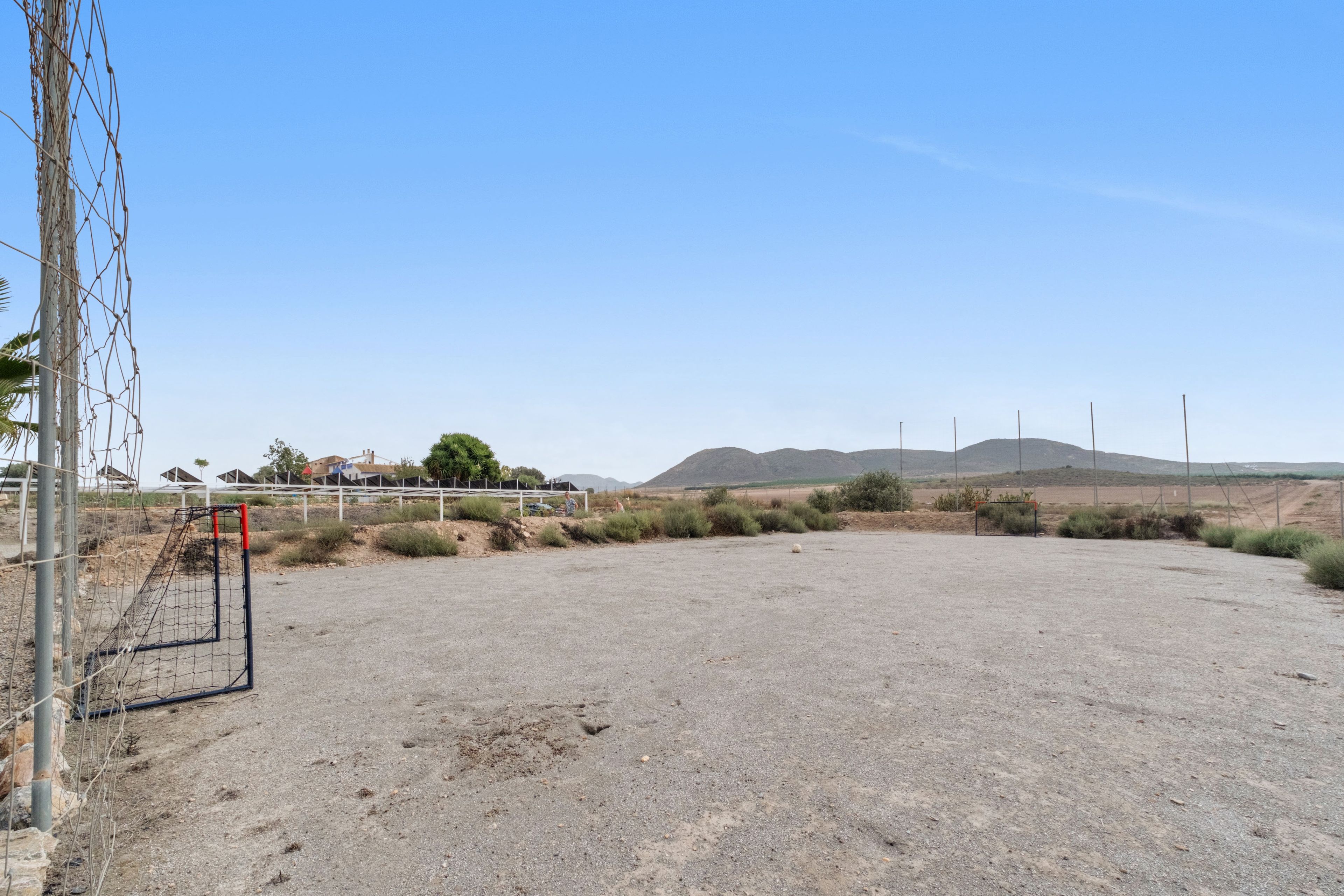 Un campo aperto e ben curato, con un palo di una porta da calcio e una recinzione.