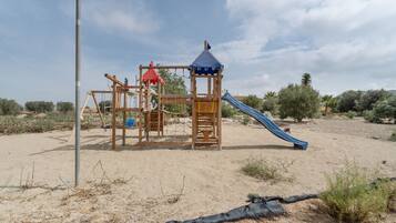Un parque infantil con tobogán y estructuras para escalar.