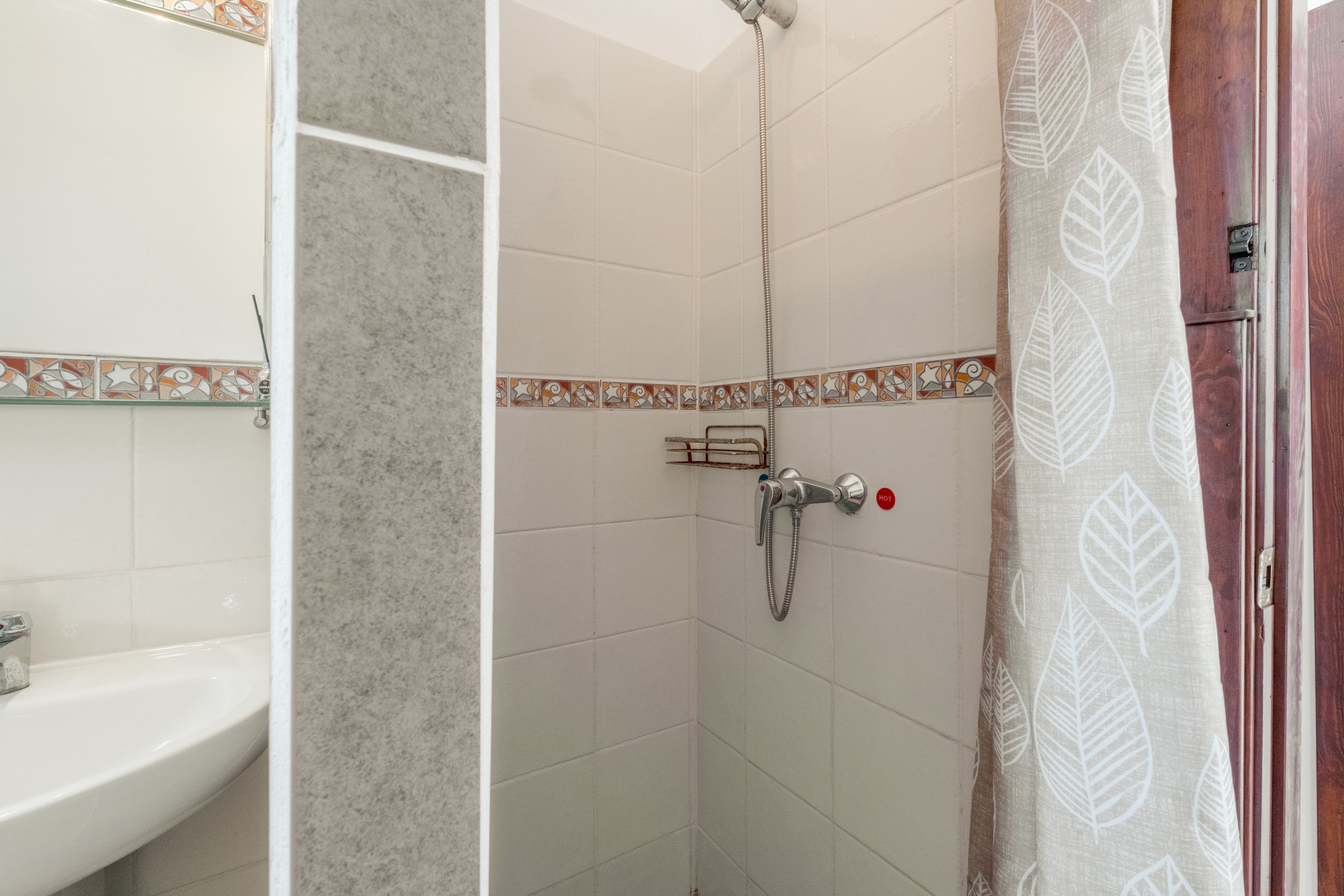 Un baño con ducha, lavabo y espejo.