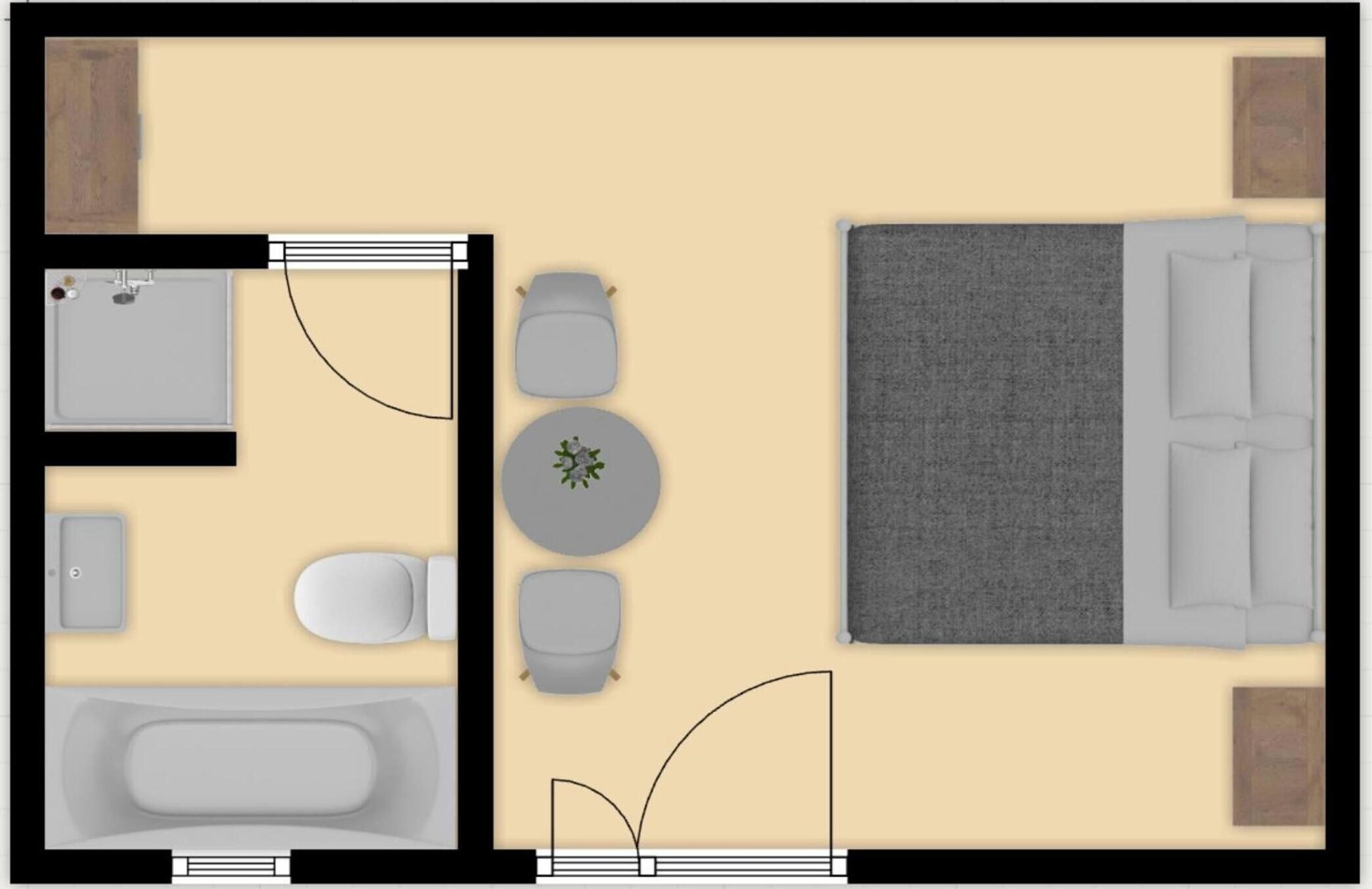 Distribución de una habitación de hotel con cama, zona de estar y baño.