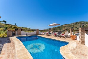 A swimming pool with lounge chairs and a barbecue area, surrounded by a white wall and a view of hills. - Villa Rosafina - Three Bedroom Villa, Sleeps 6 (Frigiliana)